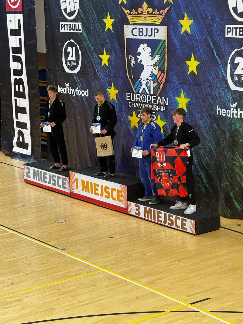Zawodnicy na podium XI Mistrzostw Europy CBJJP, z flagą BJJ Międzyrzecz