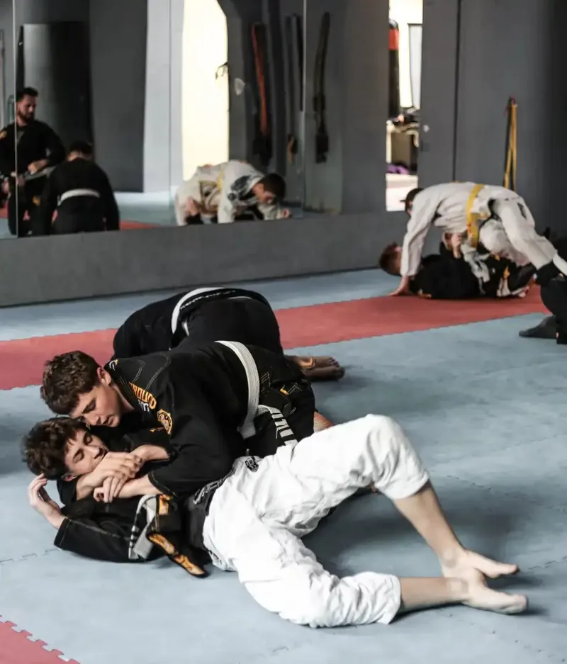 Sparing w parterze, w tle zawodnicy na macie